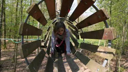 Fille passant dans un tuyan en bois