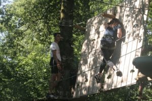 Adulte sur passage mur parcours découverte d'accrobranche